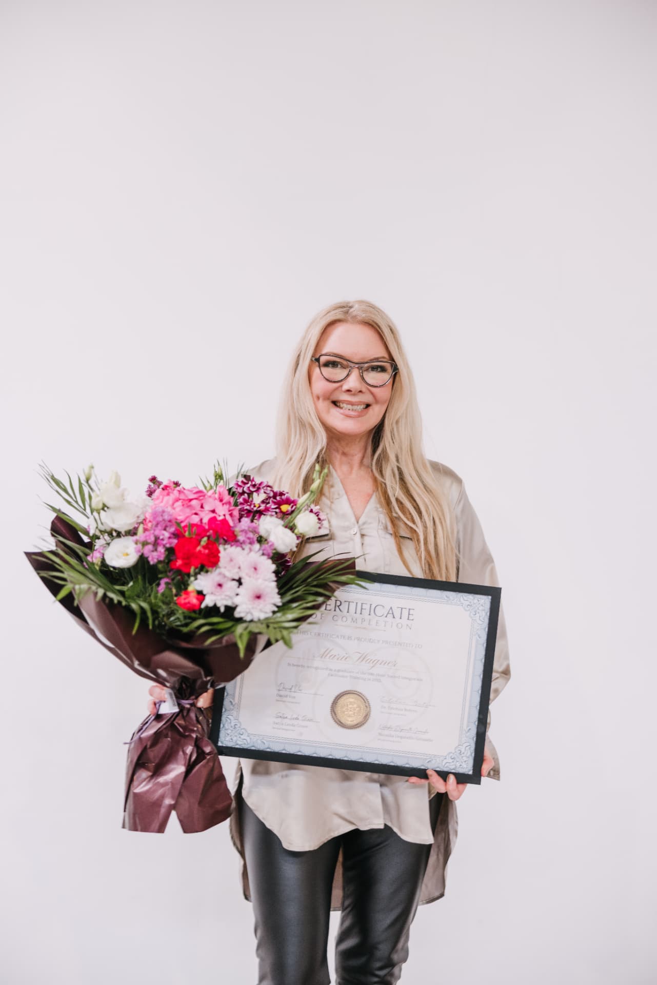 Marie holding flowers and her certificate of completion